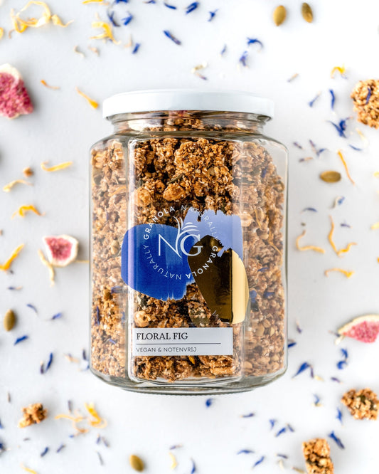 Glass jar of chunky granola with ingredients on the background